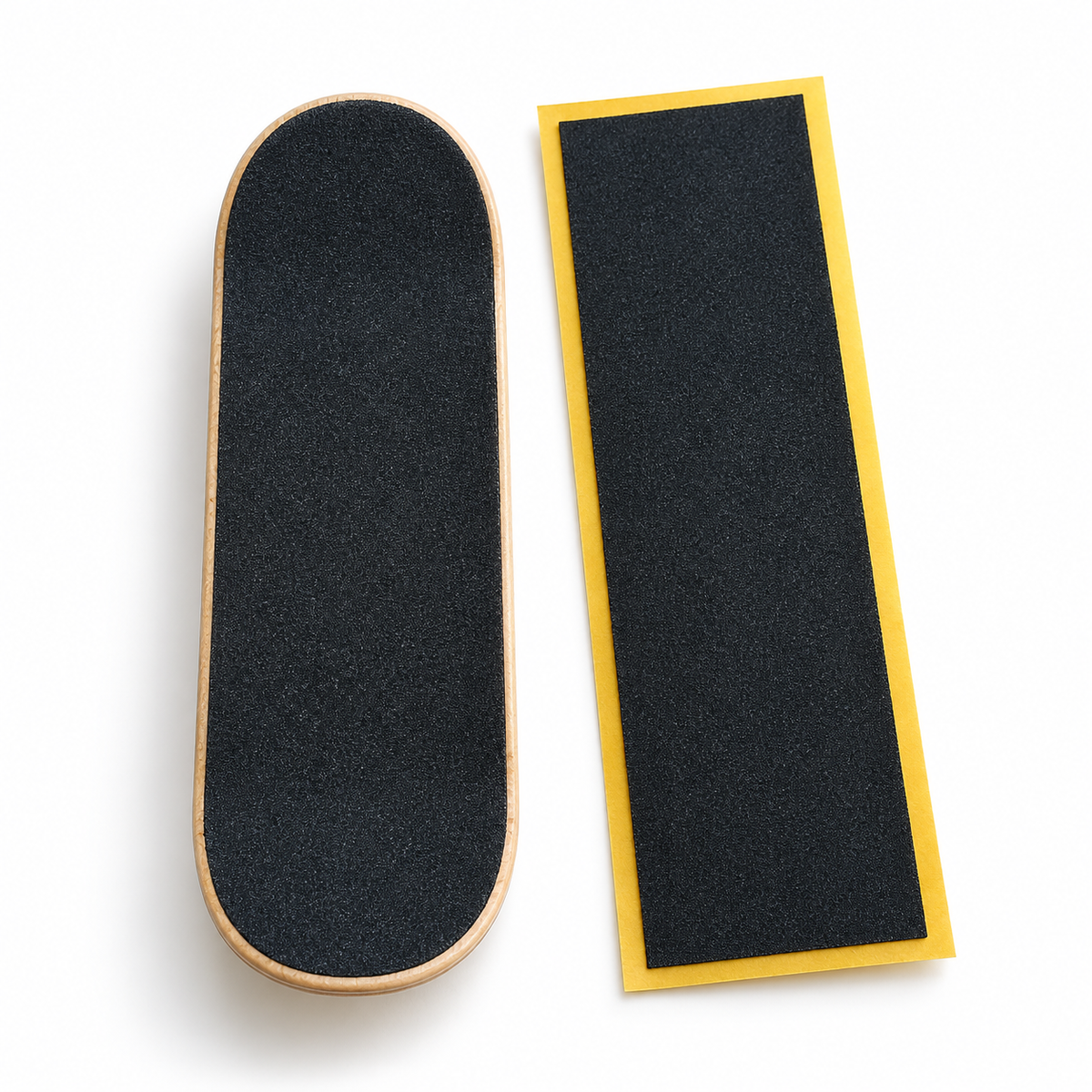 Fingerboard grip tape applied to a deck, next to an uncut sheet